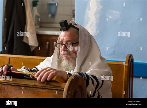 A Jewish Man In Prayer Shawl Reading The Torah In A Synagogue In Safed