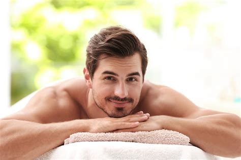 Premium Photo Handsome Young Man Relaxing On Massage Table In Spa Salon