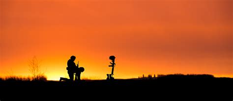 Soldier Kneeling In Front Of A Grave Sunset Copy Space