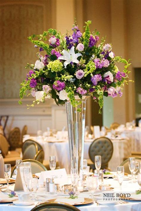 Table arrangements for your wedding in romantic purple and blue hues. Tall table centerpiece with purple and white flowers | Table arrangements wedding, Spring ...