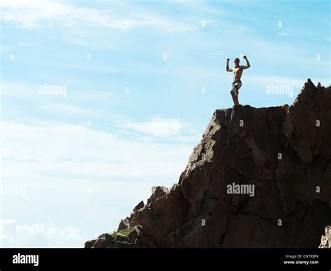 Man Cheering On Top Of Rocky Hillside Stock Photo Alamy