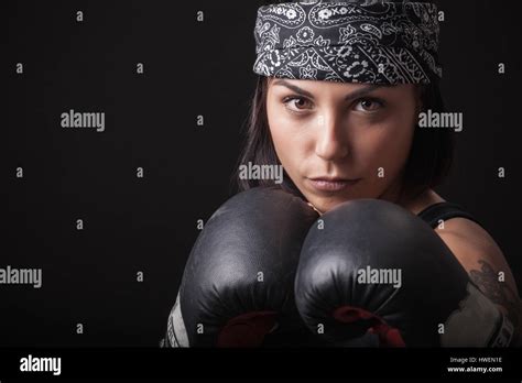 Portrait Of Young Woman Wearing Boxing Gloves In Fighting Stance Stock