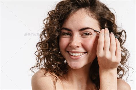 Half Naked Curly Woman Plucking Her Eyebrows And Looking At Camera Stock Photo By Vadymvdrobot