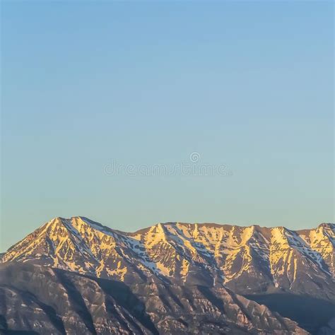 Square Rugged Mountain With Steep Peaks Covered With Snow Against Vast