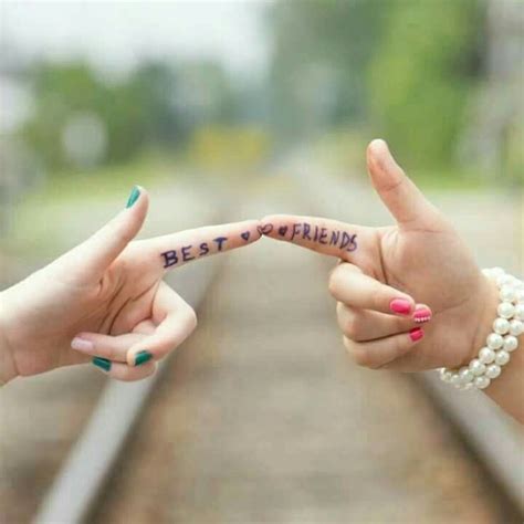 Two Women Holding Out Their Fingers With The Words Best Friends Written On Them