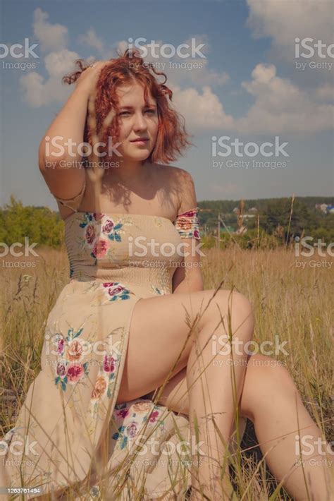 Redhaired Curlyhaired Girl In A Summer Dress Posing In The Village