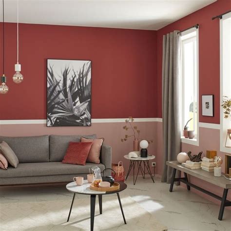 a living room with red walls and grey couches coffee table in the middle