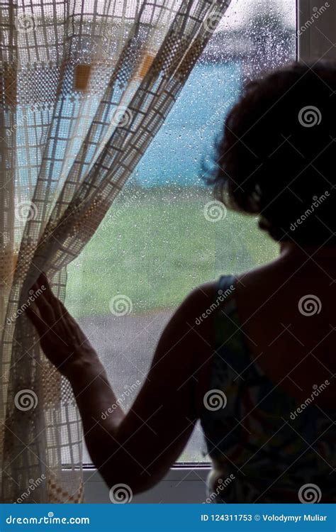 Une Femme Regarde La Fenêtre En Tant Quelle Pleut Gouttes De Pluie Sur