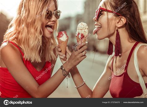 Two Beautiful Alluring Young Adult Sensuous Beauties Holding Ice Creams