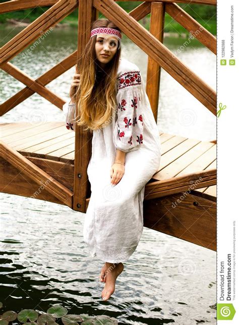Steep Slender Ukrainian Woman Resting Sitting On A Wooden Decorative Bridge Over The Water On A
