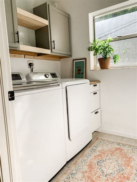 A White Washer And Dryer Sitting In A Kitchen Next To A Window With