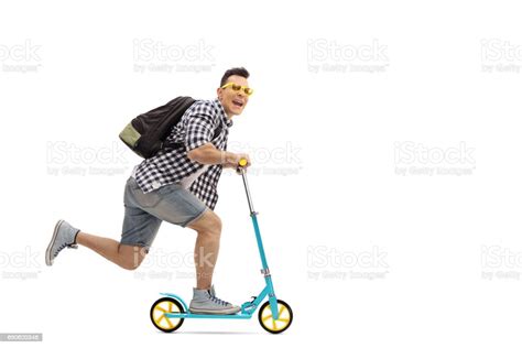 Full Length Portrait Of An Overjoyed Guy Riding A Scooter Photos Et
