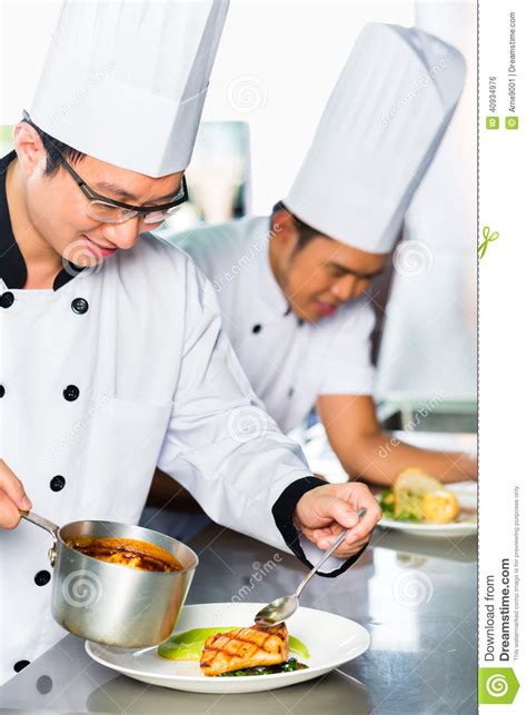 Asian Chefs In Restaurant Kitchen Cooking Stock Photo