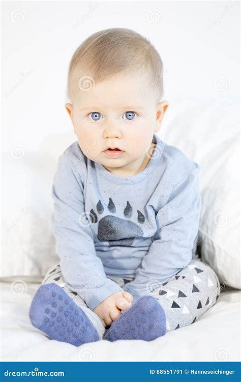 Beautiful Baby Boy Sitting In Bed On White Background Stock Image