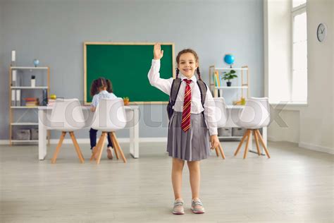 Back To School Little Schoolgirl In Uniform Raised Hands Up Standing