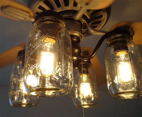 Three Mason Jar Lights Are Hanging From The Ceiling In Front Of A Fan