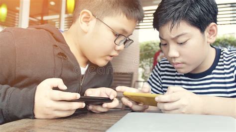 Asian Boy Playing Mobile Game On Smart Phone Together Stock Image