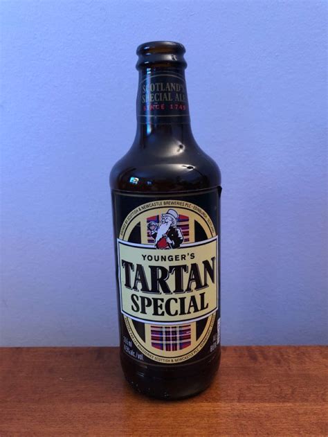 A Bottle Of Tartan Special Sitting On A Table With A Blue Wall In The