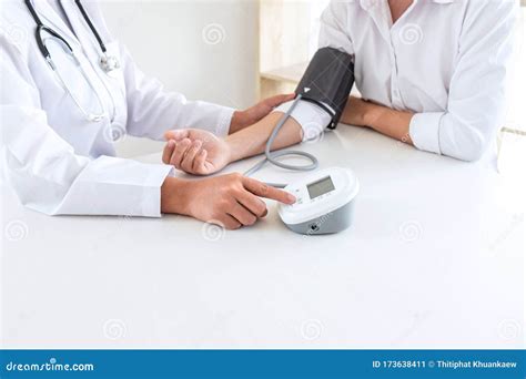 Doctor Using Blood Pressure Monitor And Stethoscope Checking Measuring