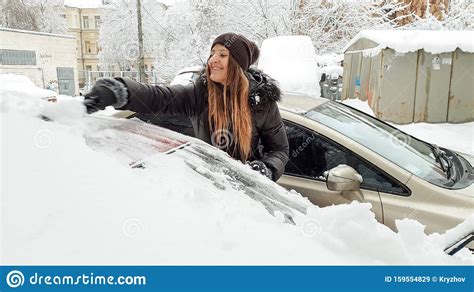 Photo Of Smiling Girl In Jacket Clean Up The Snow Covered Car