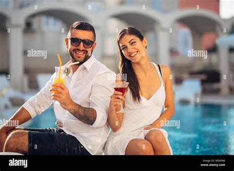 Attractive Couple Enjoying Summer Vacation Near The Pool In Exotic Vacation Resortattending