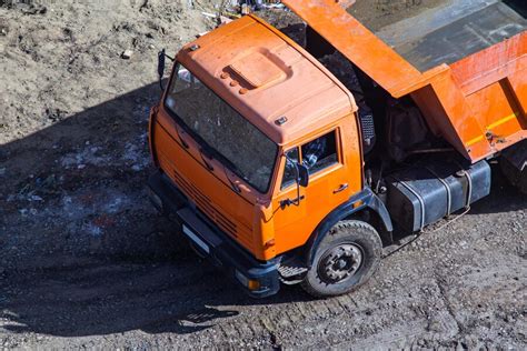 Premium Photo Dump Truck Unloading Soil At Construction Site