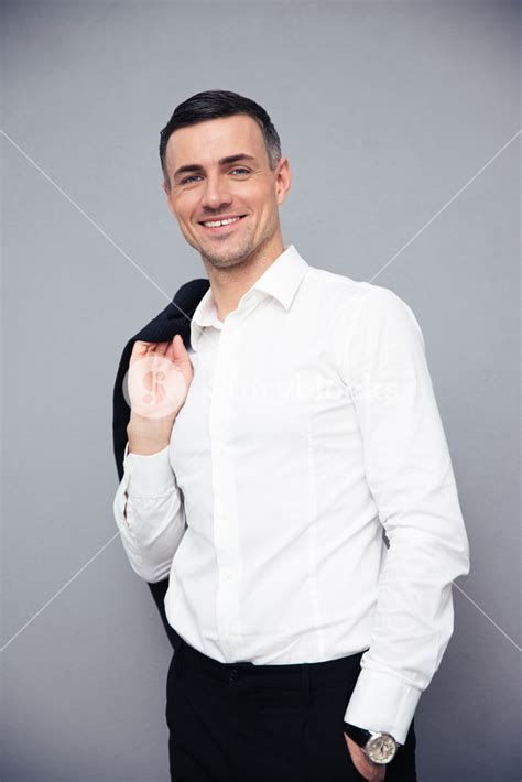 Smiling Businessman Holding Jacket On Shoulder Royalty Free Stock Image