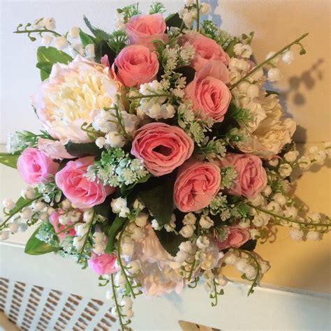 An Artificial Wedding Bouquet Of Pink Rose Peony And Lily Of The Valley