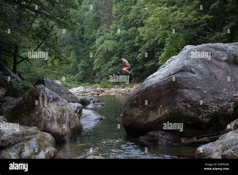 Isaiah Ardoin, 10, jumps off a rock into a swimming hole at the North