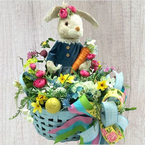 A Stuffed Rabbit Sitting In A Basket Filled With Flowers And Other