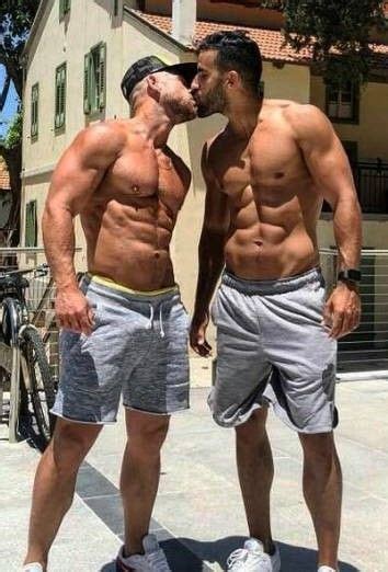 Two Men Standing Next To Each Other In Shorts