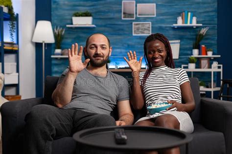 Pov Of Interracial Young Couple Waving At Videoconference Call Stock