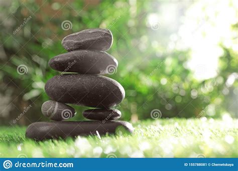 Stack Of Stones On Green Against Blurred Background Space For Text