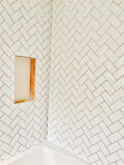 The Corner Of A Bathroom With White Tiles