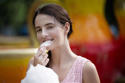 Cute Caucasian Girl In Amusement Park Is Eating Pink Candyfloss