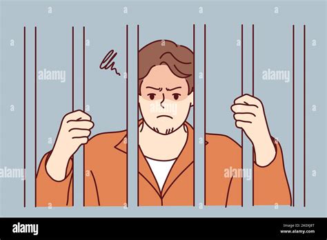 Unhappy man in robe behind bars in jail. Angry male criminal imprisoned