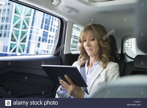 Businesswoman Using Digital Tablet In Backseat Of Car Stock Photo Alamy