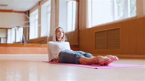 Young Woman Gymnast Lying On The Floor And Doing Exercises On Her Legs