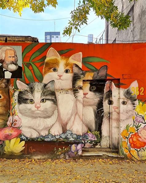 Several Cats Painted On The Side Of A Building