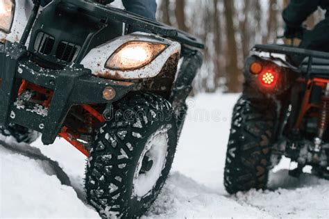 Close Up View Of Vehicles Two People Are Riding Atv In The Winter