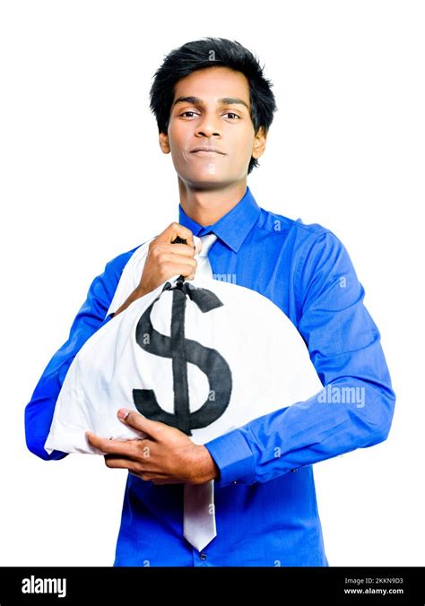 A Young Asian Busness Man Hugs A Large Money Bag Full Of Dollars Tightly To His Chest Conceptual