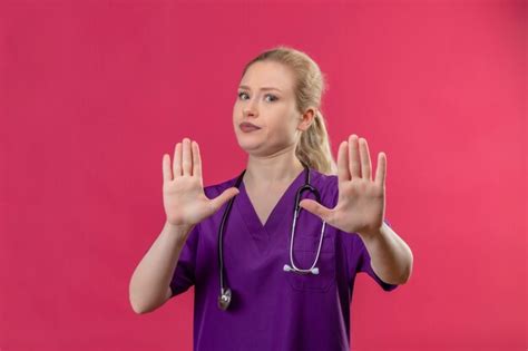 Free Photo Young Doctor Wearing Purple Medical Gown And Stethoscope Shows Stop Gesture On