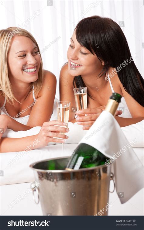 Two Women Lesbian Couple Toasting With Champagne In Luxury Hotel Room