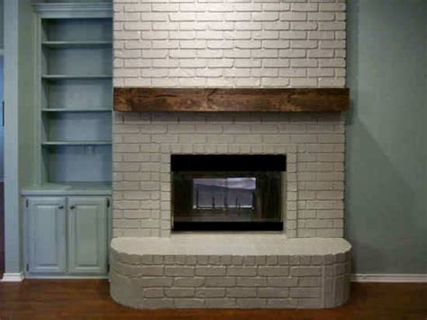 Create an earthy aura by combining a wood mantel with a brick fireplace painted white. Rough-Hewn Wood DIY Fireplace Mantel - Addicted 2 Decorating®