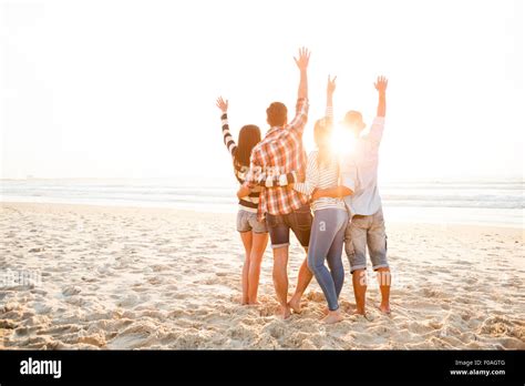 Group Of Friends At The Beach And Watching The Sunset Stock Photo Alamy