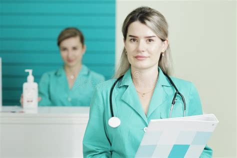 Two Female Doctors Or Nurses Looking At The Camera Stethoscope On The