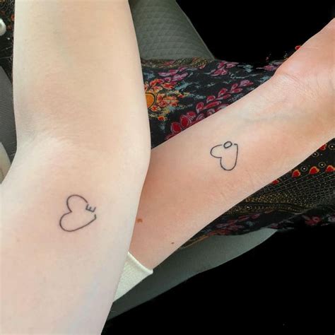 Two People With Matching Tattoos On Their Arms One Has A Heart And The