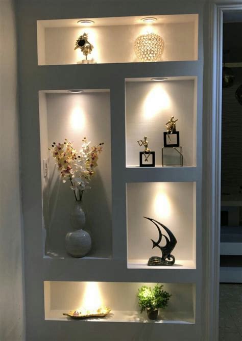 A White Shelf Filled With Vases And Lights