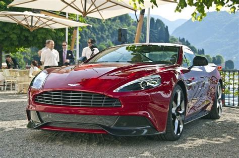 A Red Sports Car Parked In Front Of An Outdoor Dining Area With Tables