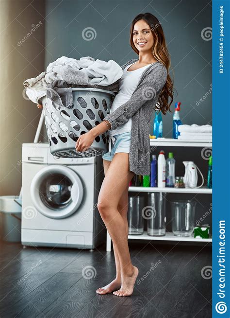 Im On Laundry Duty Today Shot Of A Young Attractive Woman Doing Her Laundry At Home Stock